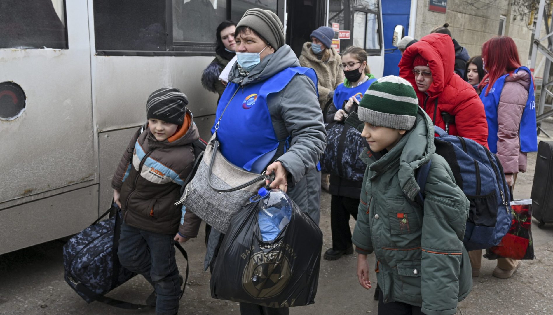 People evacuated from the Donetsk and Luhansk regions, the territory controlled by a pro-Russia separatist in eastern Ukraine, leave a bus to be taken to temporary residences in other regions of Russia, in Taganrog, Russia, Tuesday, Feb. 22, 2022.  