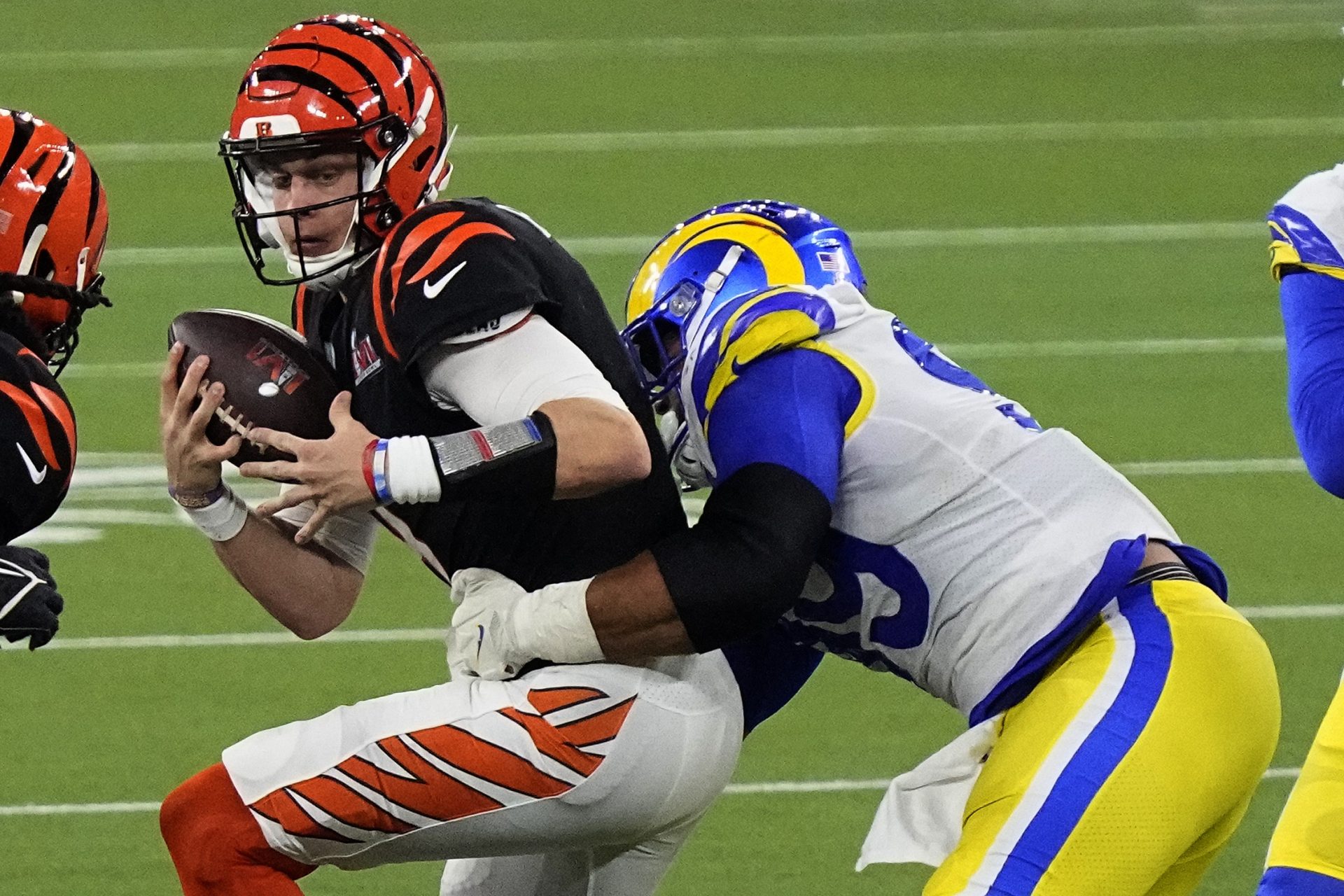 Los Angeles Rams defensive end Aaron Donald (99) tackles Cincinnati Bengals quarterback Joe Burrow (9) during the second half of the NFL Super Bowl 56 football game Sunday, Feb. 13, 2022, in Inglewood, Calif. The Los Angeles Rams won 23-20.