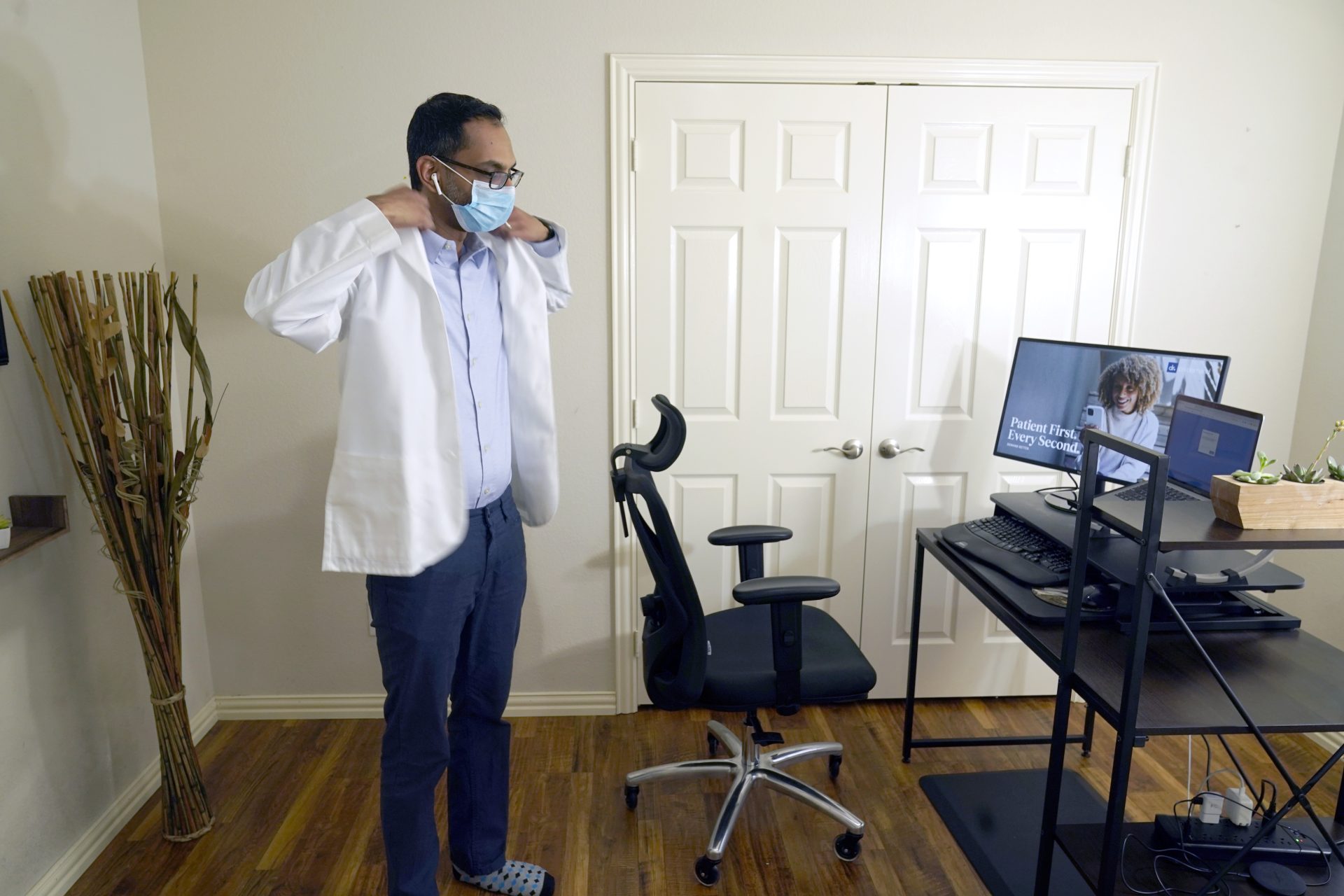 Medical director of Doctor on Demand Dr. Vibin Roy prepares to conduct an online visit with a patient from his work station at home, April 23, 2021, in Keller, Texas.