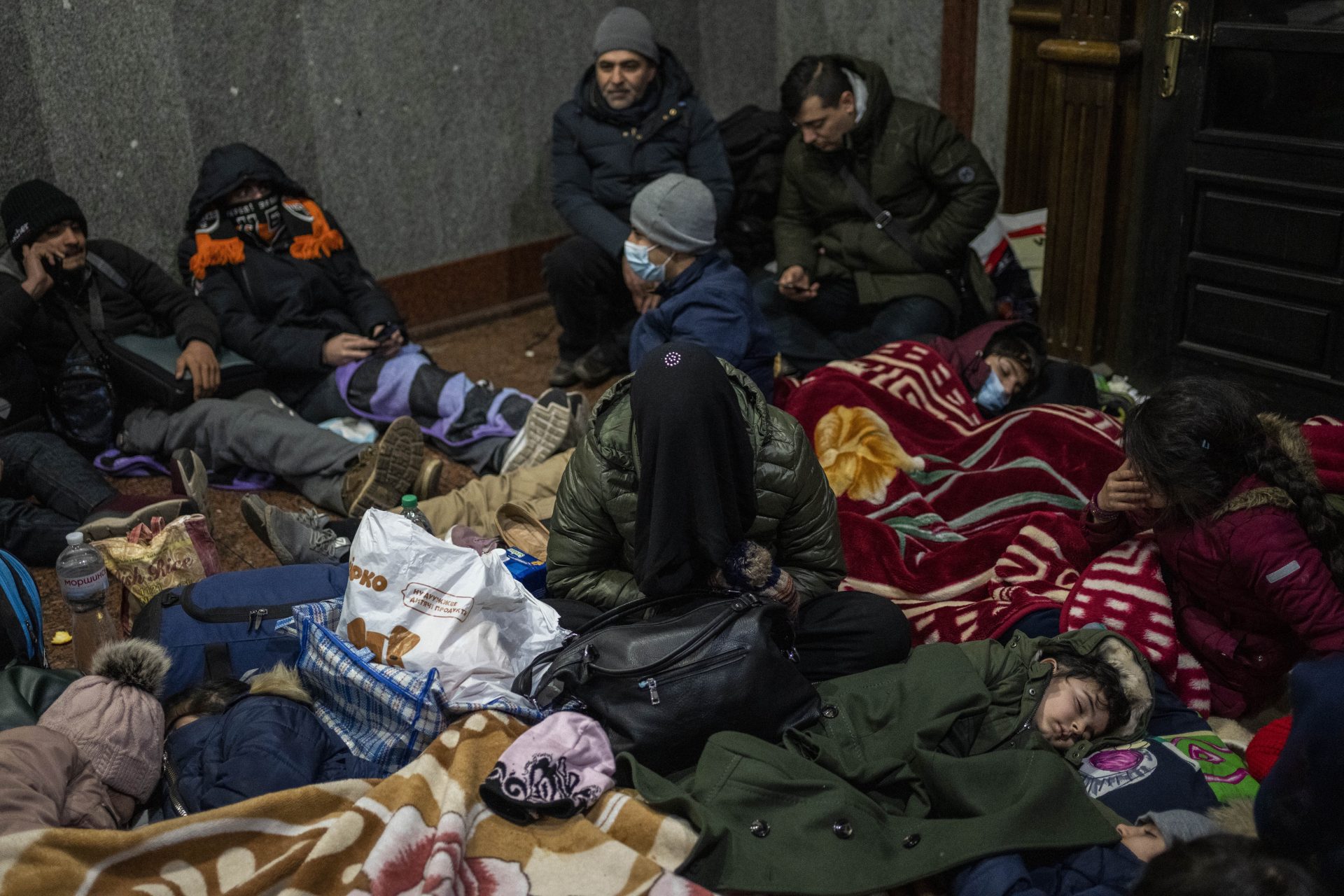 Afghans trying to flee Ukraine sleep inside Lviv railway station, Monday, Feb. 28, 2022, in Lviv, west Ukraine. Russia's military assault on Ukraine has entered its fifth day, forcing hundreds of thousands of Ukrainians and foreign residents to escape from war and seek refuge in neighboring countries.