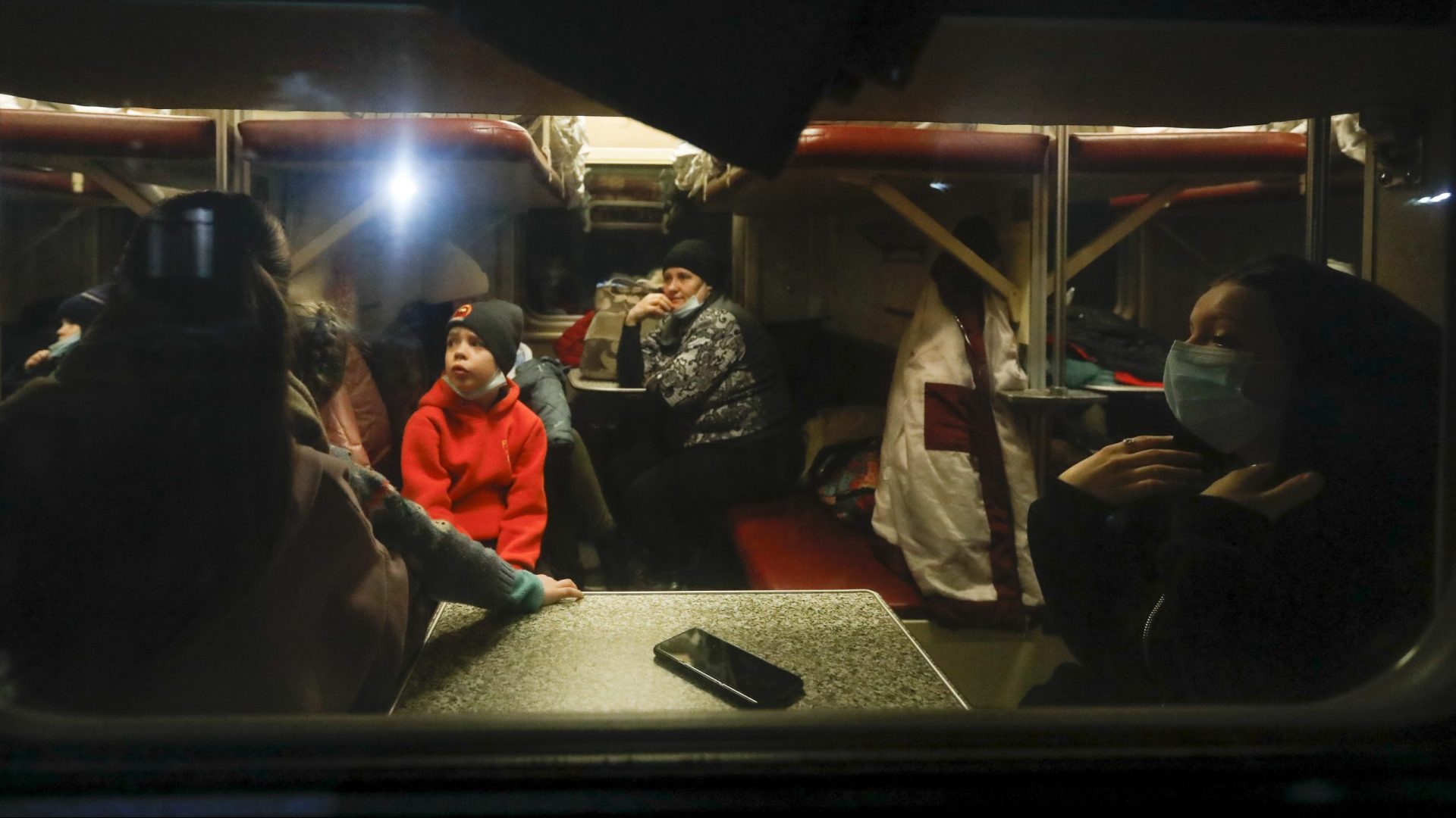 People from the Donetsk and Luhansk regions, the territory controlled by a pro-Russia separatist governments in eastern Ukraine, sit a train carriage waiting to be taken to temporary residences in the Volgograd region, at the railway station in Volzhsky, Volgograd region, Russia, on Sunday, Feb. 20, 2022.