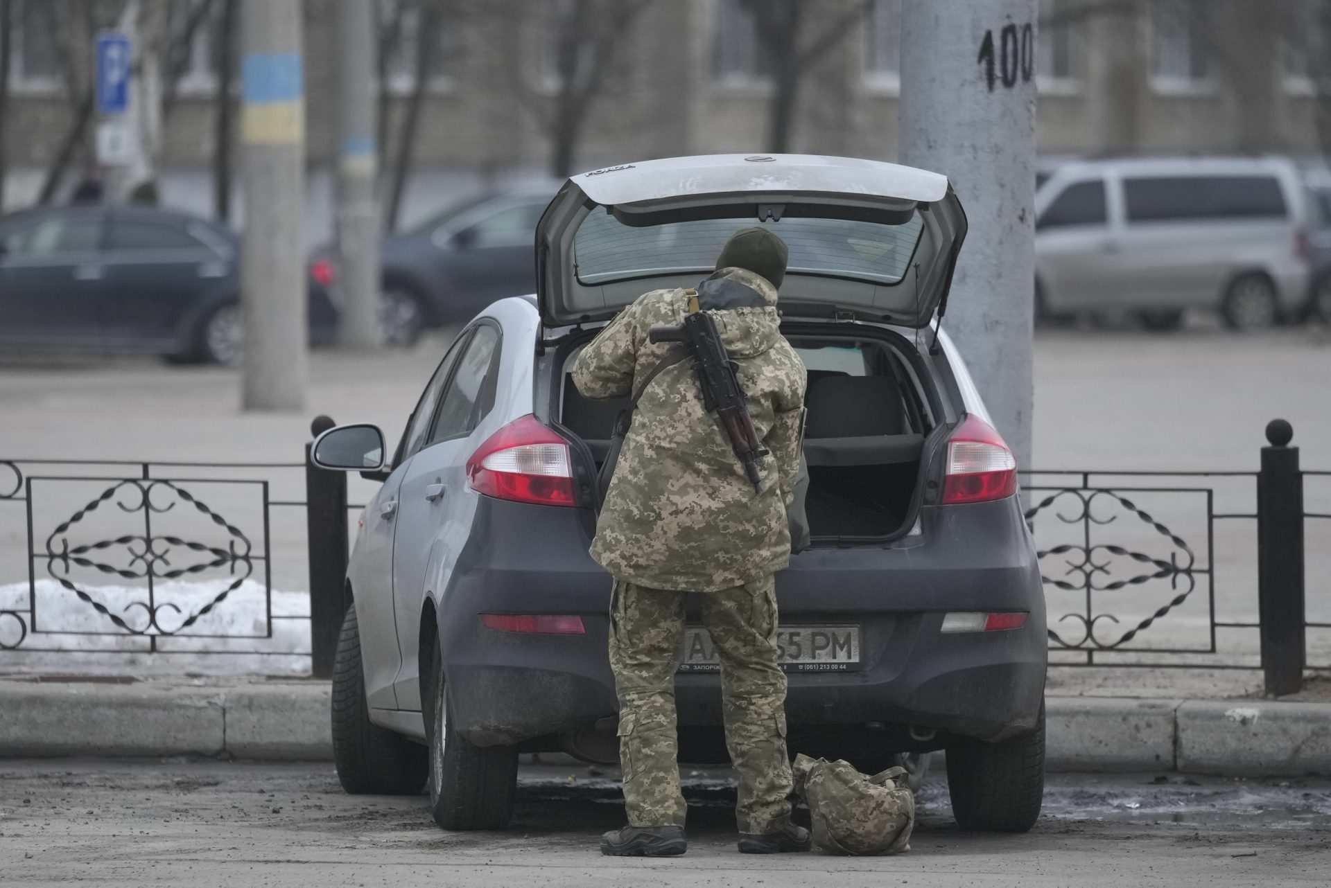 A member of the Ukrainian military takes items from the back of a car in Sievierodonetsk, the Luhansk region, eastern Ukraine, Thursday, Feb. 24, 2022.