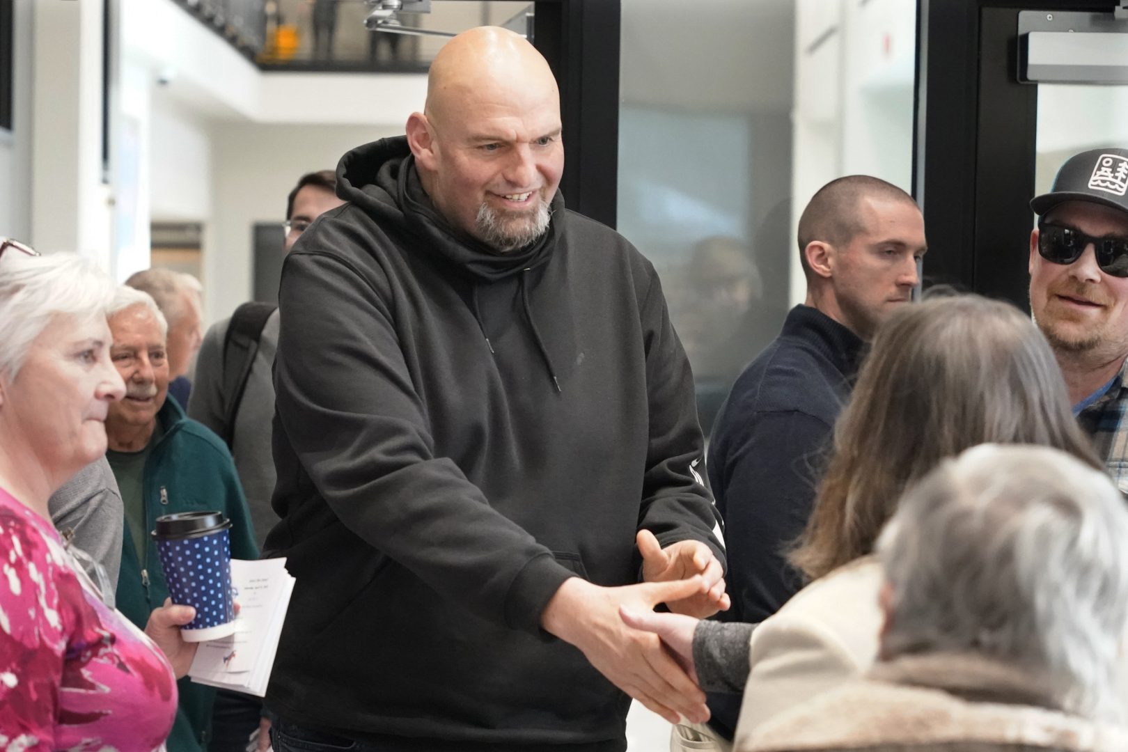 In this photo made on Friday, March 4, 2022, Pennsylvania Lt. Gov. John Fetterman, center, visits with people attending a Democratic Party event for candidates to meet and collect signatures for ballot petitions for the upcoming Pennsylvania primary election, at the Steamfitters Technology Center in Harmony, Pa. Fetterman is running for the party nomination for the U.S. Senate. The irreverent, blunt, 6 feet 8, tattooed Fetterman faces the Pennsylvania's Democratic Party committee backed U.S. Rep. Conor Lamb and Malcolm Kenyatta, a second-term state representative from Philadelphia. (AP Photo/Keith Srakocic)