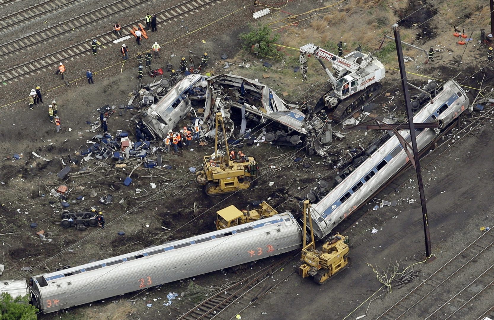 In this Wednesday, May 13, 2015, file photo, emergency personnel work at the scene of a derailment in Philadelphia of an Amtrak train headed to New York. A Philadelphia jury is expected weigh criminal charges Friday, March 4, 2022, against Amtrak engineer Brandon Bostian over the deadly derailment.