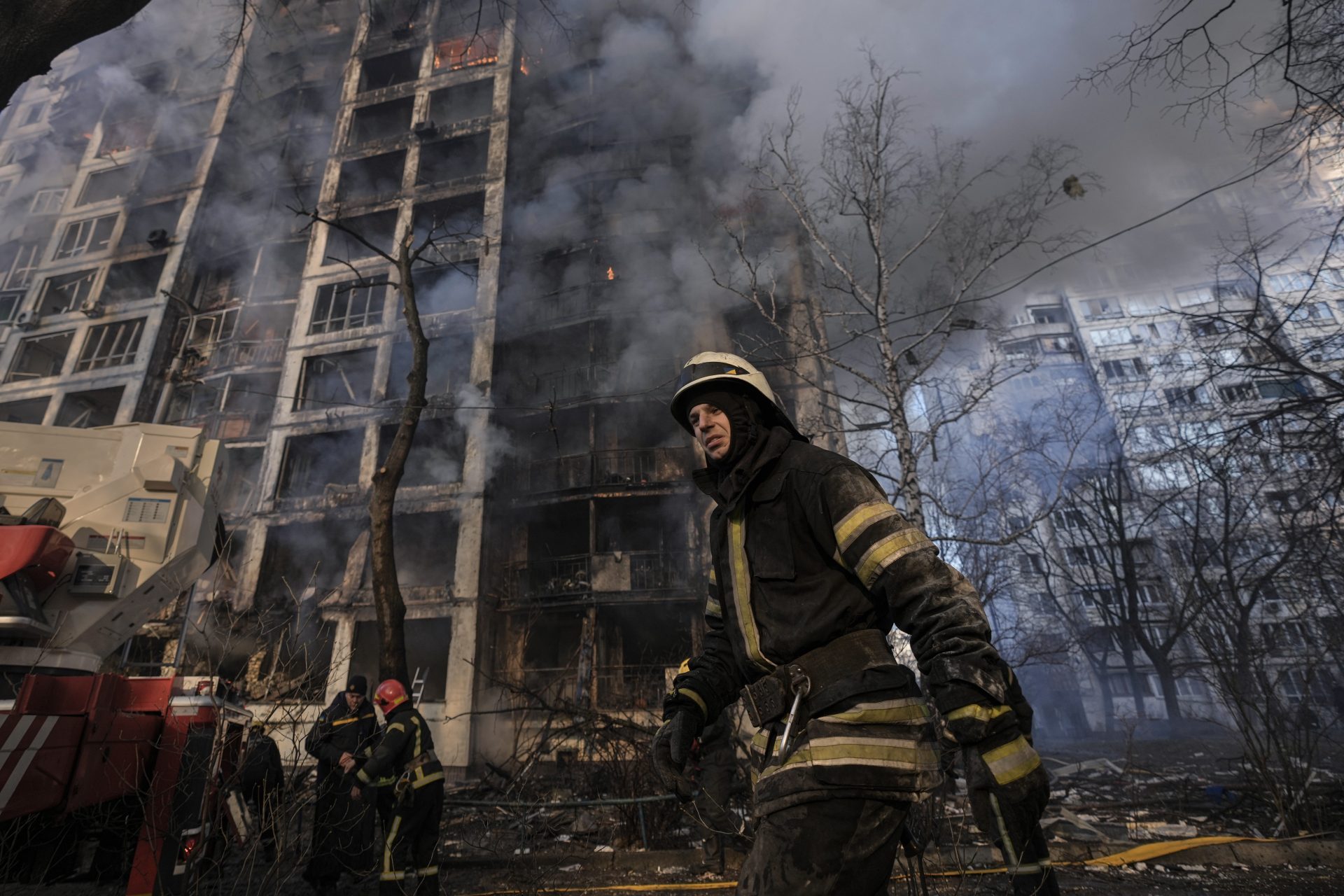 A firefighter walks outside a destroyed apartment building after a bombing in a residential area in Kyiv, Ukraine, Tuesday, March 15, 2022.