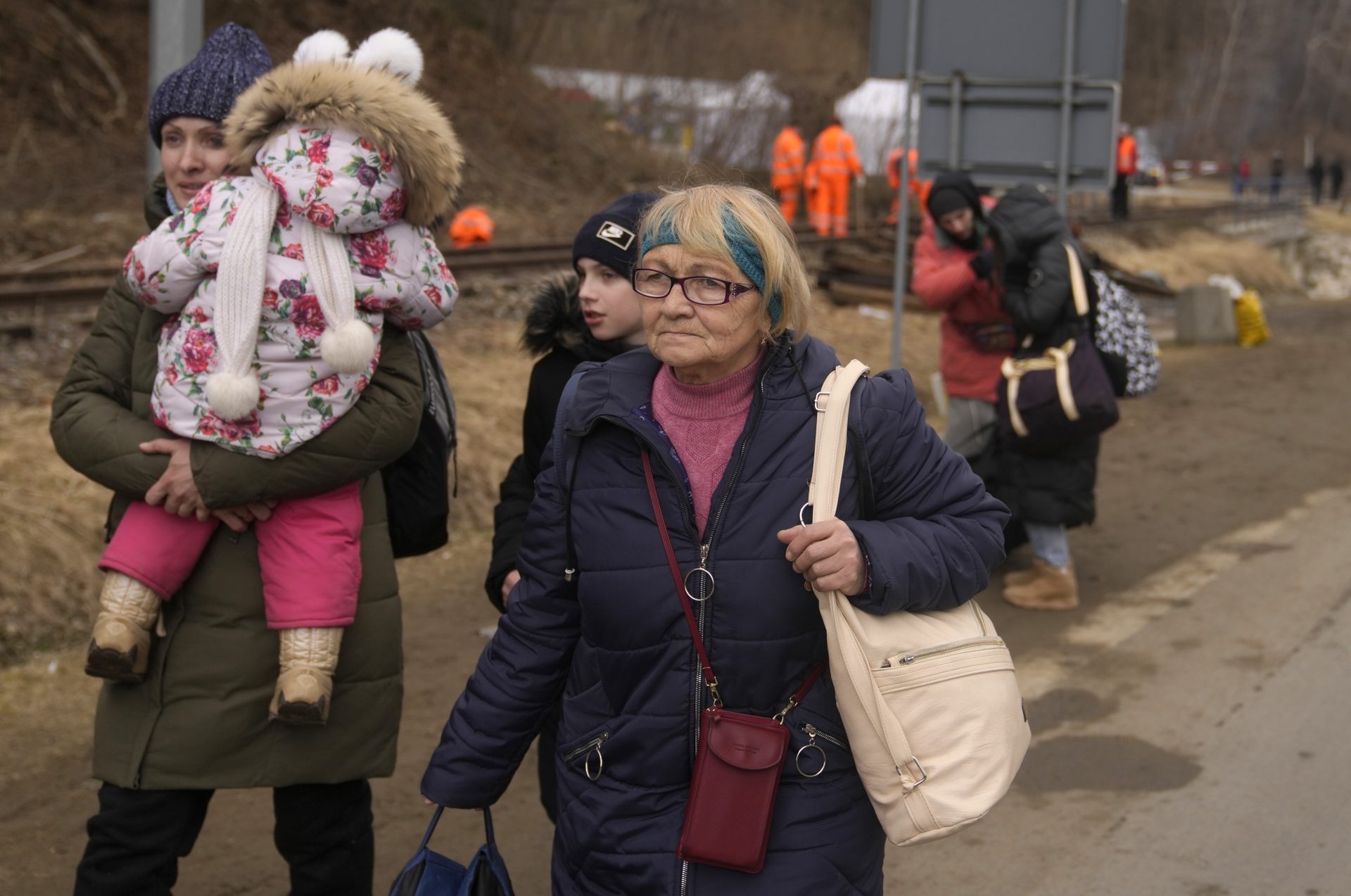 A woman holds her child as she walks with others, who fled Ukraine, at the border crossing in Kroscienko, Poland, Tuesday, March 8, 2022.