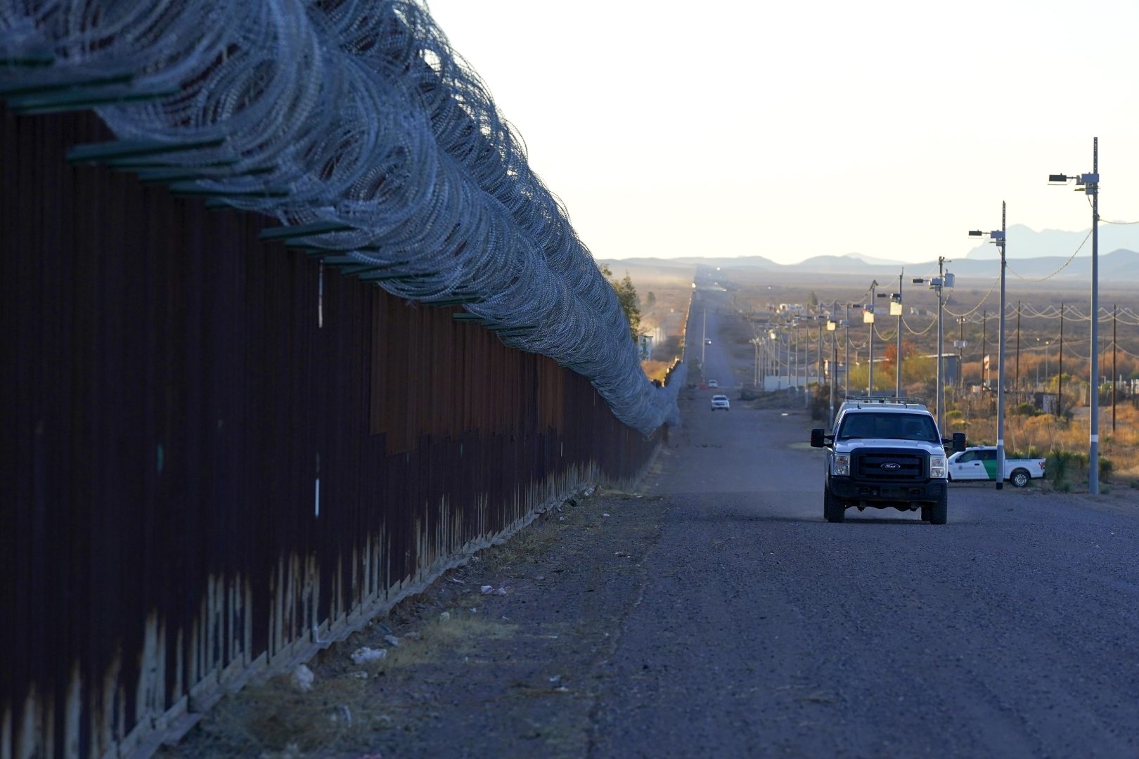 FILE - A U.S. Border Patrol vehicle drives along the border fence at the U.S.-Mexico border wall, on Dec. 15, 2020, in Douglas, Ariz. 