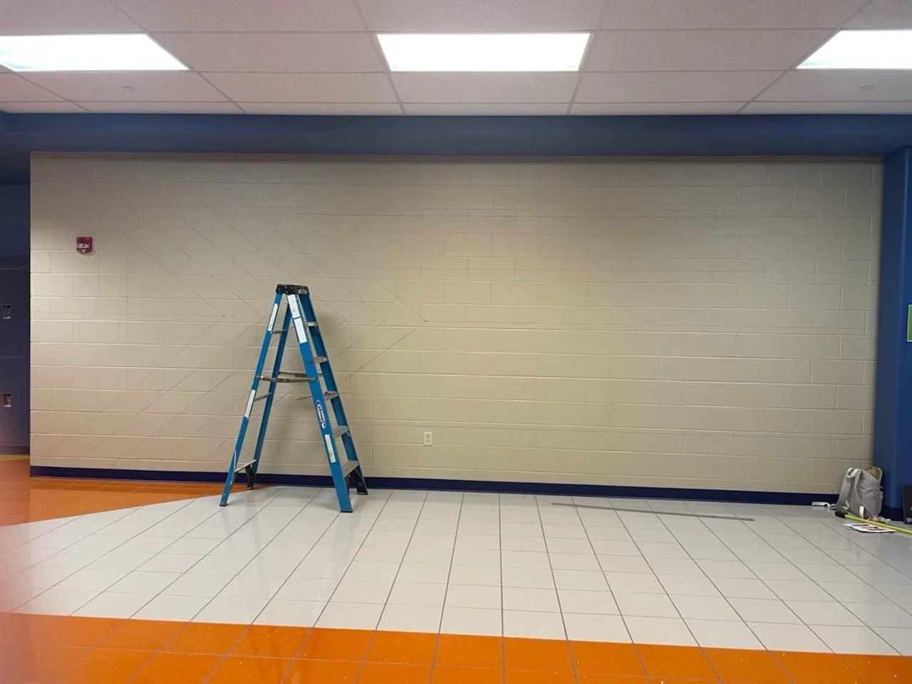 The outline of student Oliver Bryant's LGBTQ+ pride flag mural is faintly visible on the wall at Chambersburg Area Senior High School in this photo taken prior to the work being painted over by the school 