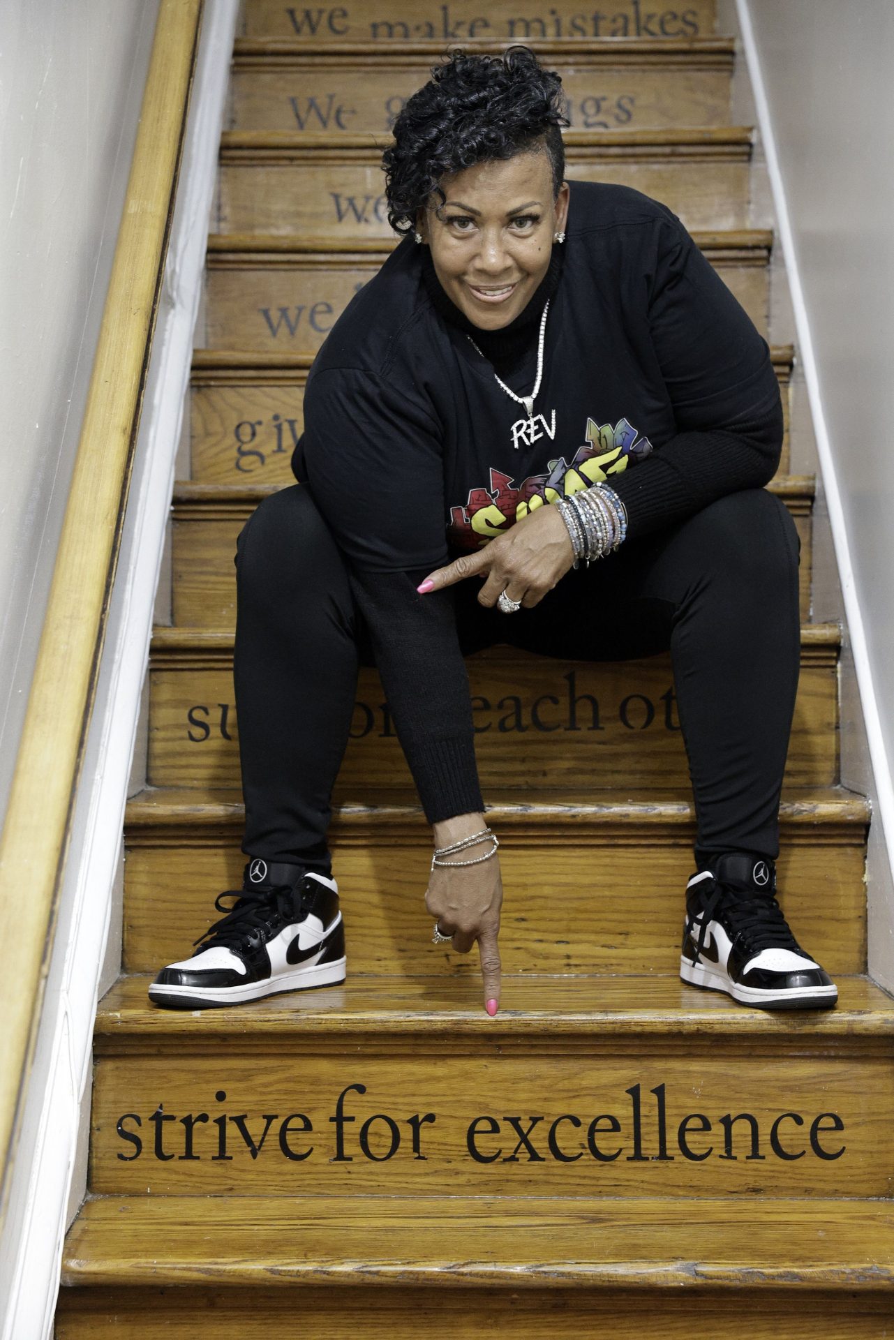 The Rev. Michelle Simmons, founder and executive director of Why Not Prosper, points to one of the inspirational messages on the staircase risers at a Why Not Prosper recovery home in Philadelphia. Her organization received a license for one of its recovery homes, and Simmons plans to seek licenses for its other facilities.