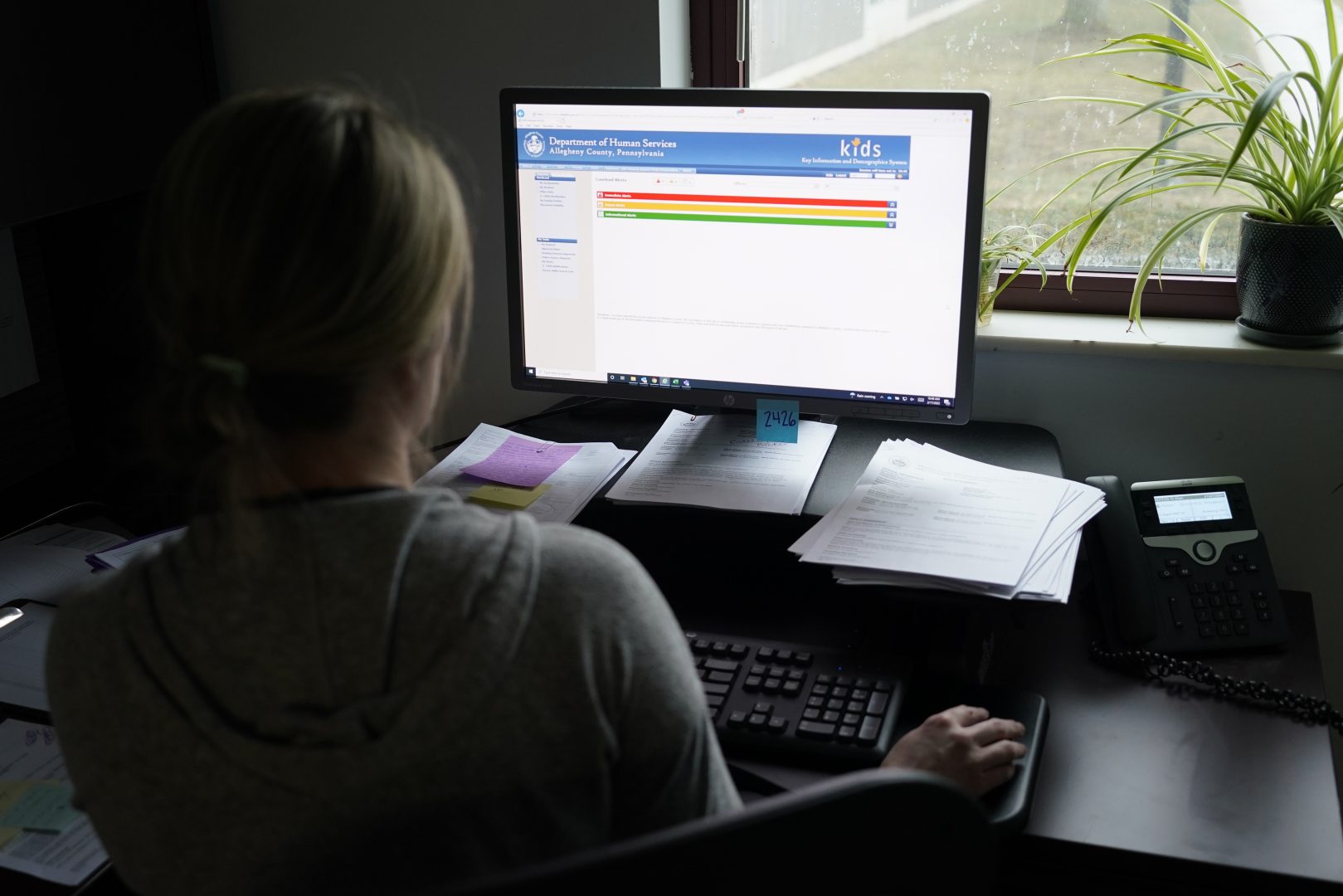 Case work supervisor Jessie Schemm looks over the first screen of software used by workers who field calls at an intake call screening center for the Allegheny County Children and Youth Services, in Penn Hills, Pa. 