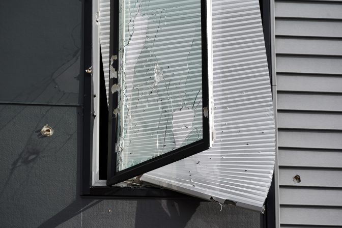 Blinds hang out of a shot out window on the second floor of the short-term rental property where police say a shooting took place in Pittsburgh early Sunday morning, April 17, 2022.