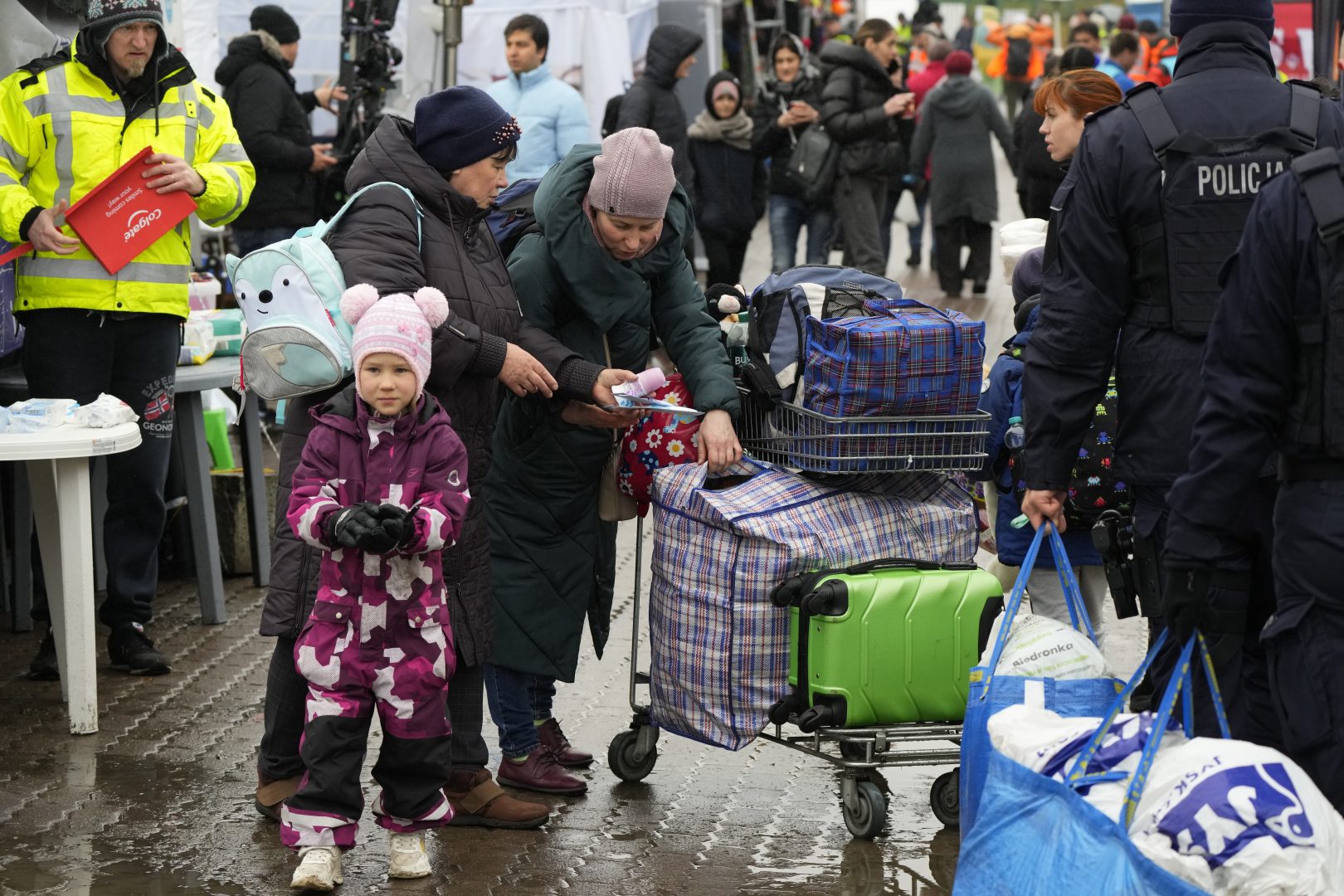 Refugees check their luggage after fleeing the war from neighbouring Ukraine at the border crossing in Medyka, southeastern Poland, Friday, April 1, 2022. Talks to stop the fighting in Ukraine resumed Friday, as another attempt to rescue civilians from the shattered and encircled city of Mariupol broke down and Russia accused the Ukrainians of a cross-border helicopter attack on an oil depot. 