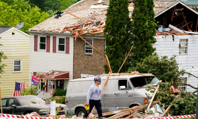 An investigator moves through the scene of a deadly explosion in a residential neighborhood in Pottstown, Pa., Friday, May 27, 2022. (AP Photo/Matt Rourke)