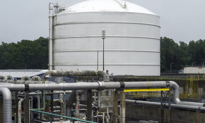 Transfer pipes carry liquified natural gas to and from a holding tank, seen in background, at Dominion Energy's Cove Point LNG Terminal in Lusby, Md., Thursday, June 12, 2014. Federal regulators concluded that Dominion Energy's proposal to export liquefied natural gas from its Cove Point terminal on the Chesapeake Bay in Maryland would pose "no significant impact" on the environment. 