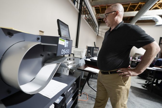 Mercer County Director of Elections, Thad Hall uses the optical scanner to continue counting ballots for the Pennsylvania primary election, Wednesday, May 18, 2022, in Mercer, Pa..
