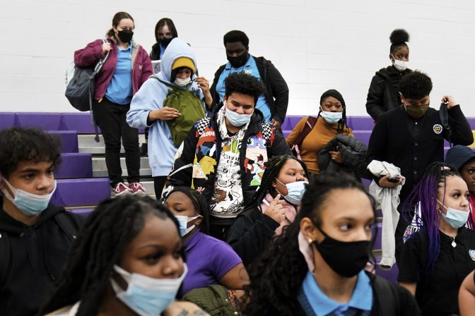 Students wearing mask as a precaution against the spread of the coronavirus line up to receive KN95 protective masks at Camden High School in Camden, N.J., Feb. 9, 2022.