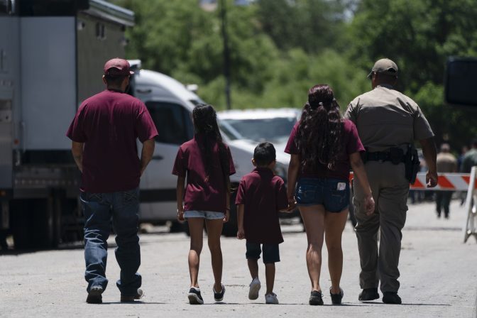 A state trooper escorts a group of family onto the campus of Robb Elementary School in Uvalde, Texas, Wednesday, May 25, 2022.