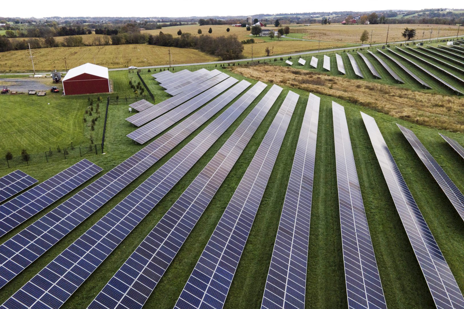 FILE - Farmland is seen with solar panels from Cypress Creek Renewables, Oct. 28, 2021, in Thurmont, Md. President Joe Biden plans to invoke the Defense Production Act to increase U.S. manufacturing of solar panels while declaring a two-year tariff exemption on panels from Southeast Asia. 