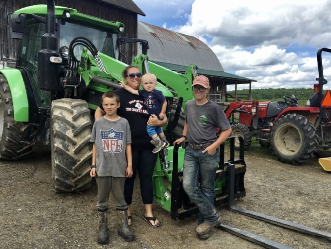 Amanda Balon, with her three sons, Logan, Connor and Garrett, at her family's farm. She's a fifth generation farmer and says noise from the cooling fans at a nearby Bitcoin mining site are disrupting her work.