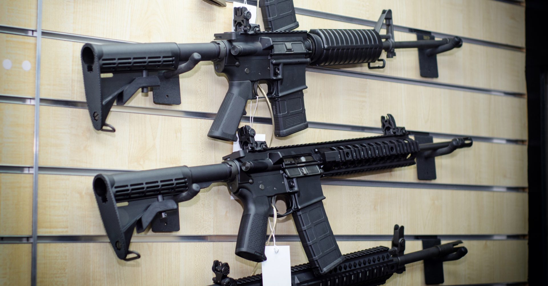 Gun wall rack with AR-15 style rifles.
