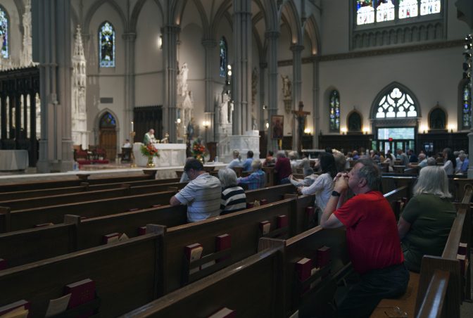 Parishioners kneel as the Very Rev. Kris Stubna leads Mass at St. Paul Catholic Cathedral in Pittsburgh on Sunday, June 26, 2022.