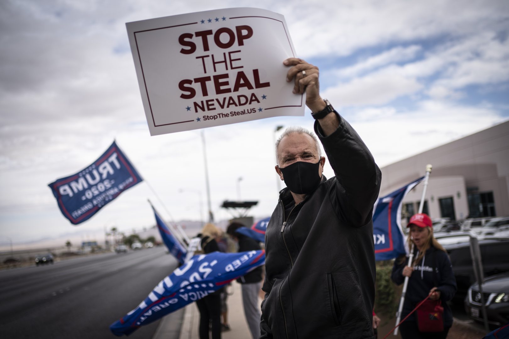 Supporters of President Donald Trump hold signs as they stand in front of the Clark County Elections Department in North Las Vegas, Nevada on November 7, 2020. 