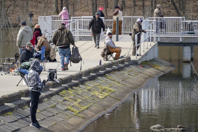 Anglers line the pier at Glade Run Lake Conservancy on opening day of trout fishing season in Pennsylvania, Saturday, April 3, 2021, in Valencia, Pa.