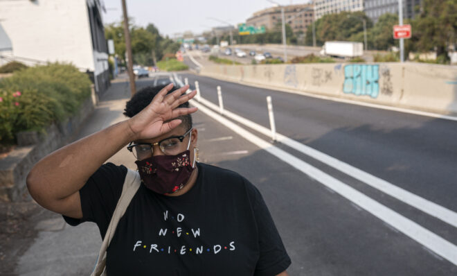 Katherine Morgan wipes sweat from her forehead while walking to work in high temperatures on Thursday, Aug. 12, 2021, in Portland, Ore. People have headed to cooling centers as the Pacific Northwest began sweltering under another major, multiday heat wave. 
