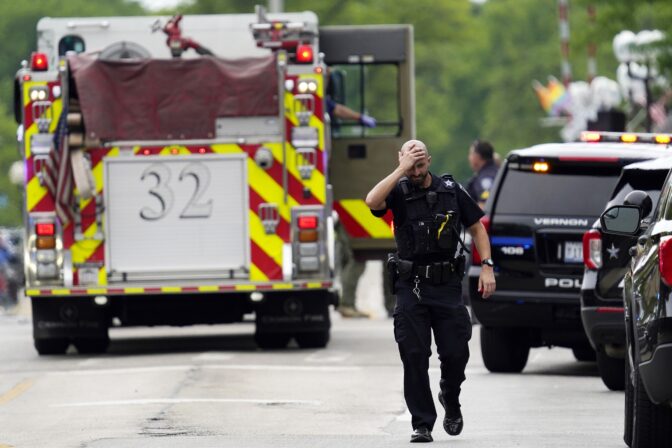 A police officer reacts as he walks in downtown Highland Park, Ill., a suburb of Chicago, Monday, July 4, 2022, where a mass shooting took place at a Highland Park Fourth of July parade. (