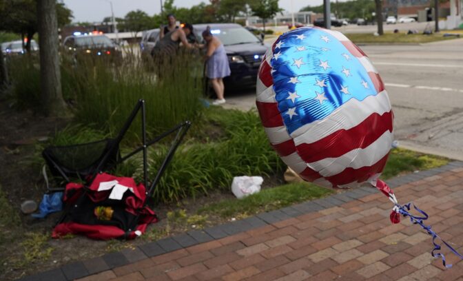 People check their belongings after a mass shooting at the Highland Park Fourth of July parade in downtown Highland Park, Ill., a suburb of Chicago, Monday, July 4, 2022.