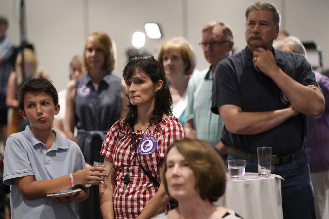 People listen as organizers speak during a Value Them Both watch party after a question involving a constitutional amendment removing abortion protections from the Kansas constitution failed, Tuesday, Aug. 2, 2022, in Overland Park, Kan.