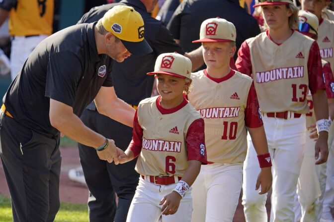 Santa Clara, Utah's Brogan Oliverson (6) shakes hands with Nolensville, Tenn., manager Randy Huth at the end of a baseball game at the Little League World Series in South Williamsport, Pa., Friday, Aug. 19, 2022. Tennessee won 11-2.