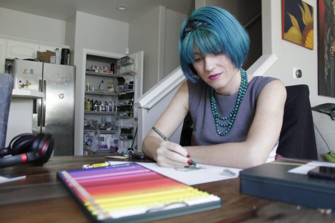 Lynn Hunt, who took out between $45,000 and $50,000 in student loans and was a Pell Grant recipient, uses colored pencil to fill in a sketch at home in Beaverton, Ore., on Wednesday, Aug. 24, 2022.