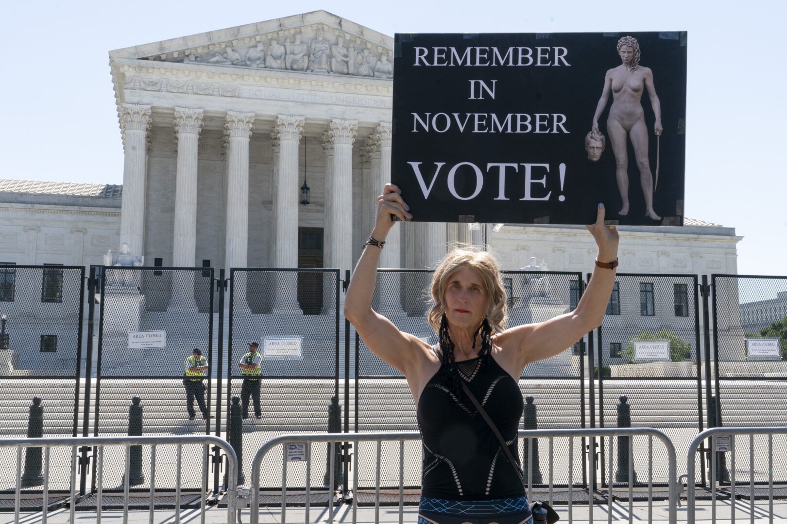 Nicky Sundt, of Washington, holds a sign with an image depicting Medusa that says, 