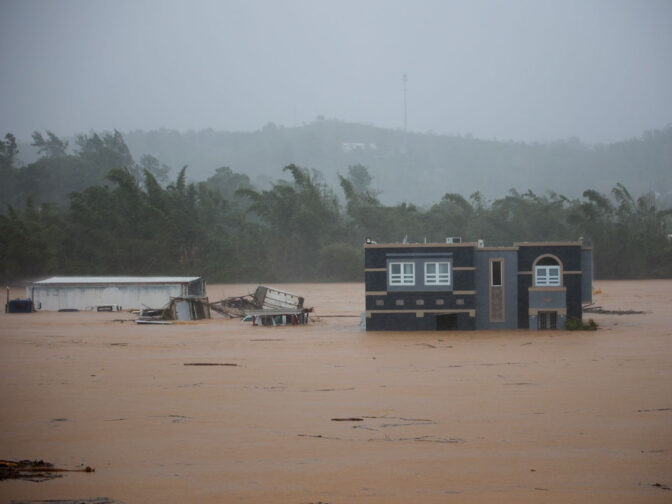 Three people inside a house await rescue from the floods caused by Hurricane Fiona in Cayey, Puerto Rico on Sunday.