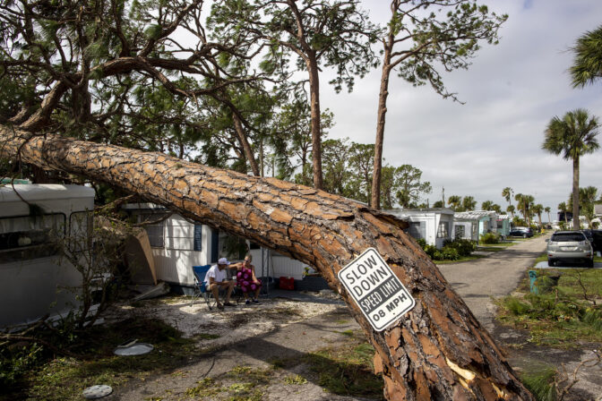 A couple sits in front of their home in Englewood Florida after hurricane Ian