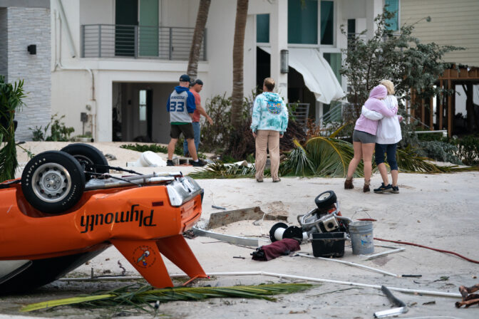 People embrace as they survey property damage from Hurricane Ian 