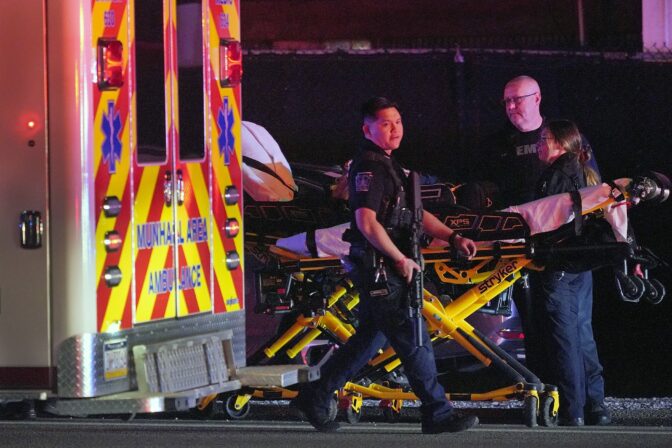 A law enforcement officer walks past an EMS crew on the scene at Kennywood Park, an amusement park in West Mifflin, Pa., early Sunday, Sept 25, 2022.