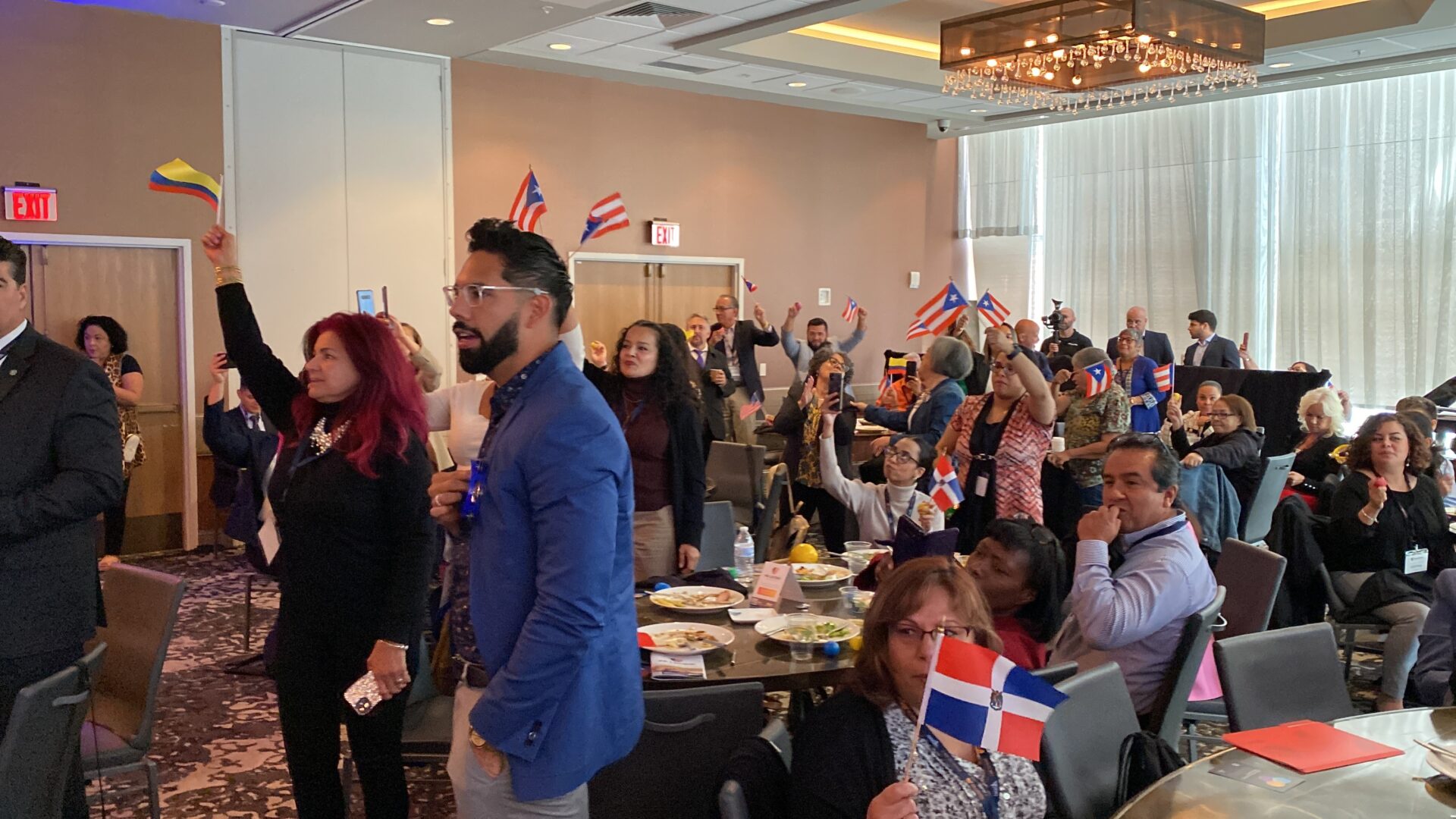 Attendees of the PA Latino Convention wave flags of their country or region of origin during a cultural celebration.