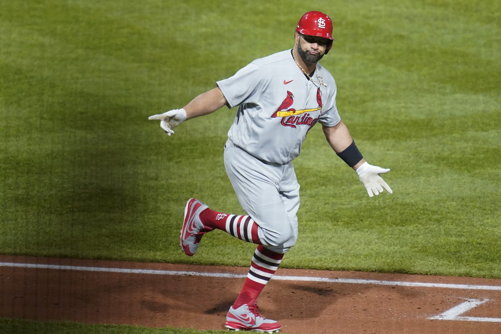 St. Louis Cardinals' Albert Pujols celebrates as he heads to first base after he hit career home run No. 703 during the fifth inning of a baseball game against the Pittsburgh Pirates, Monday, Oct. 3, 2022, in Pittsburgh. 