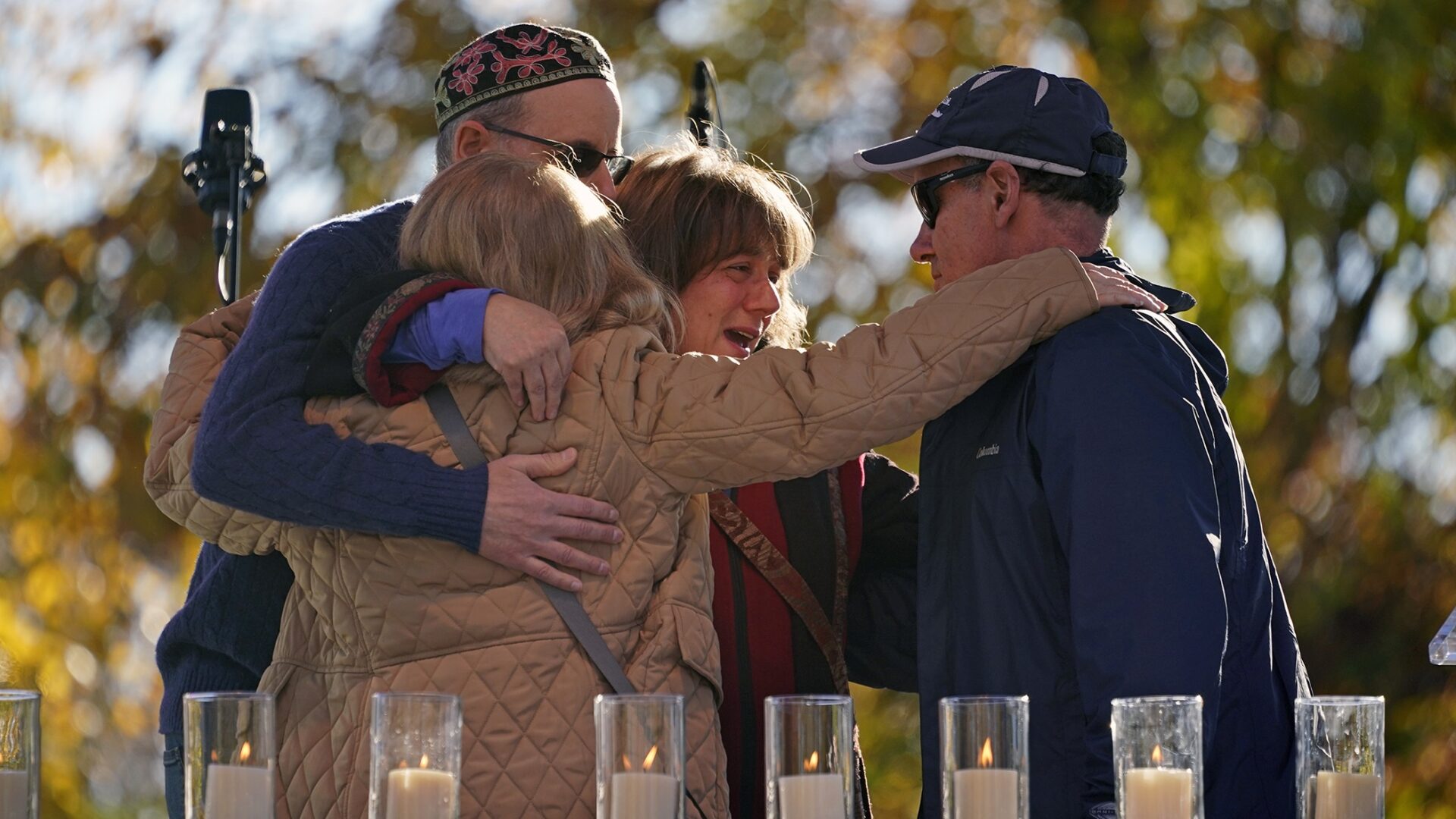 People hug after lighting a candle in memory of Melvin Wax, one of 11 worshippers killed four years ago when a gunman opened fire at the Tree of Life synagogue in the Squirrel Hill neighborhood, during a commemoration ceremony in Pittsburgh on Thursday, Oct. 27, 2022. 