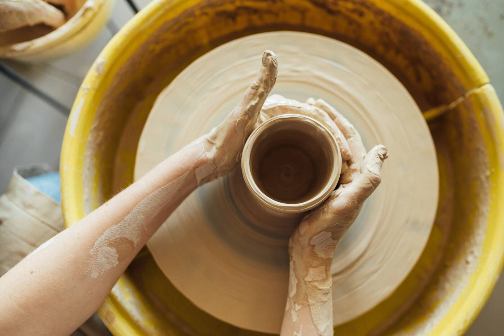 hands of a potter.  Potter making ceramic pot on the potter's wheel.