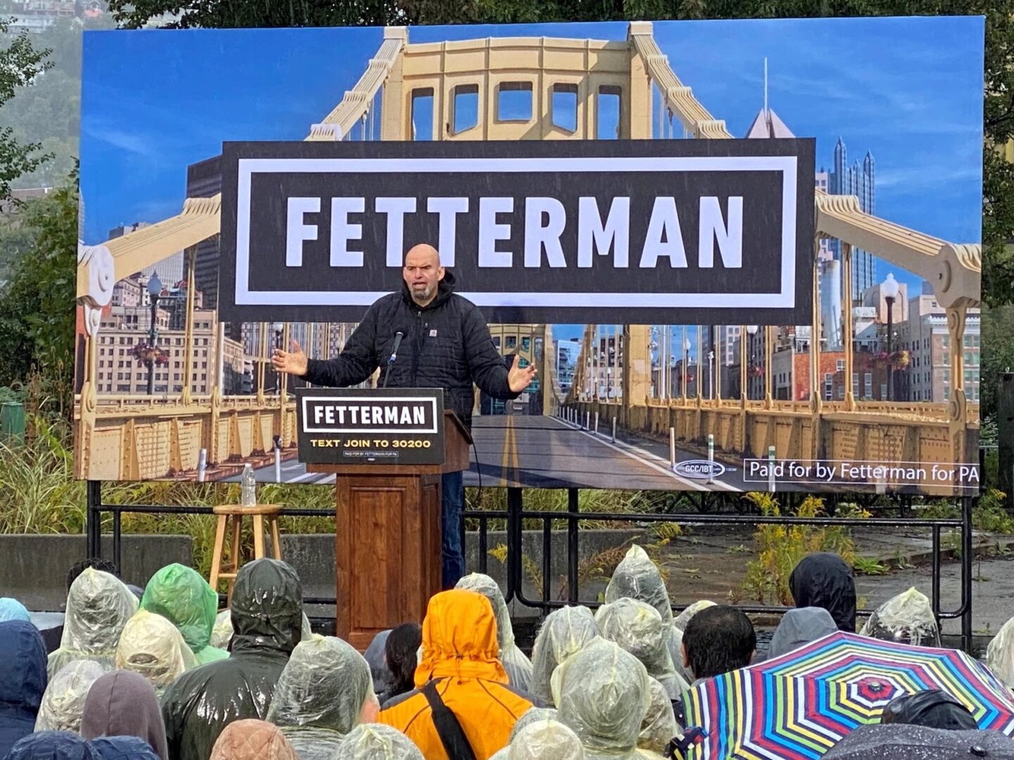 Pennsylvania Lt. Gov. John Fetterman speaks to a crowd in the rain at a U.S. Senate campaign rally in Pittsburgh.
