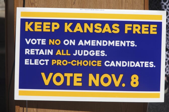 This photo shows a sign for a new Kansas group, Keep Kansas Free, seeking to push voters who support abortion rights to go to the polls, on a podium for a news conference, Thursday, Oct. 13, 2022, outside the statehouse in Topeka, Kan. The group wants voters to oppose constitutional changes on the ballot, retain Kansas Supreme Court justices and other judges on the bench and elect candidates who support abortion rights, arguing that all three will protect abortion access.