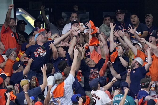 Fans reach for Houston Astros Yordan Alvarez's two-run home run against the Seattle Mariners during the sixth inning in Game 2 of an American League Division Series baseball game in Houston, Thursday, Oct. 13, 2022.