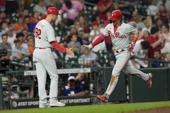 Philadelphia Phillies' Bryson Stott (5) celebrates with third base coach Dusty Wathan (62) after hitting a home run against the Houston Astros during the eighth inning of a baseball game Monday, Oct. 3, 2022, in Houston.