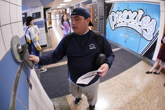 Anthony Bruno, a student at the Washington Junior High School, uses the unlocking mechanism as he leaves classes for the day to open the bag that his cell phone was sealed in during the school day, Thursday, Oct. 27, 2022, in Washington, Pa.