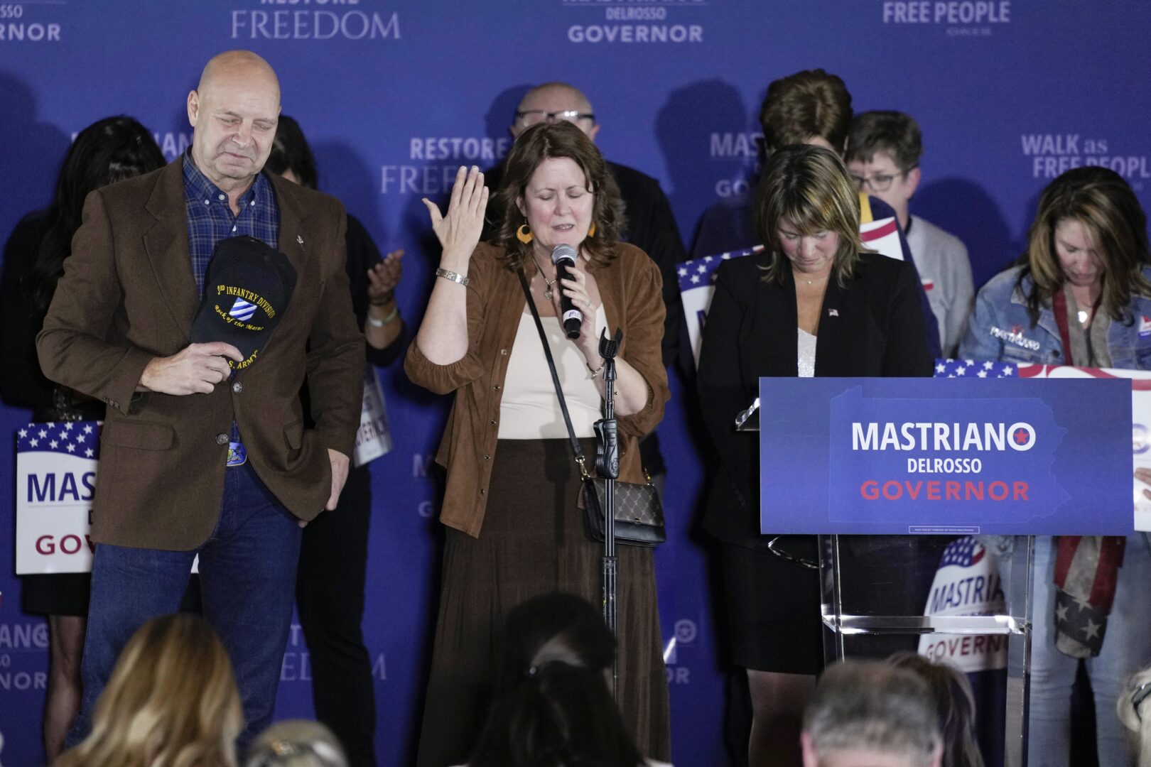 Pennsylvania Republican gubernatorial candidate Doug Mastriano, his wife Rebecca Mastriano, and running mate Carrie Lewis DelRosso pray on stage with supporters during his election night campaign gathering at the Penn Harris Hotel in Camp Hill, Pa., Tuesday, Nov. 8, 2022. Democrat Josh Shapiro won the race for governor of Pennsylvania.