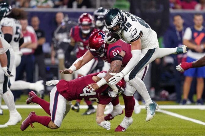 Philadelphia Eagles tight end Dallas Goedert (88) is brought down between Houston Texans linebacker Jake Hansen (49) and defensive tackle Roy Lopez (91)in the first half of an NFL football game in Houston, Thursday, Nov. 3, 2022.