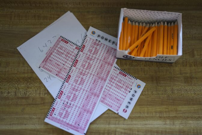 Two Powerball playslips sit on top of a piece of scratch paper at Bluebird Liquor in Hawthorne, Calif., Wednesday, Nov. 2, 2022.